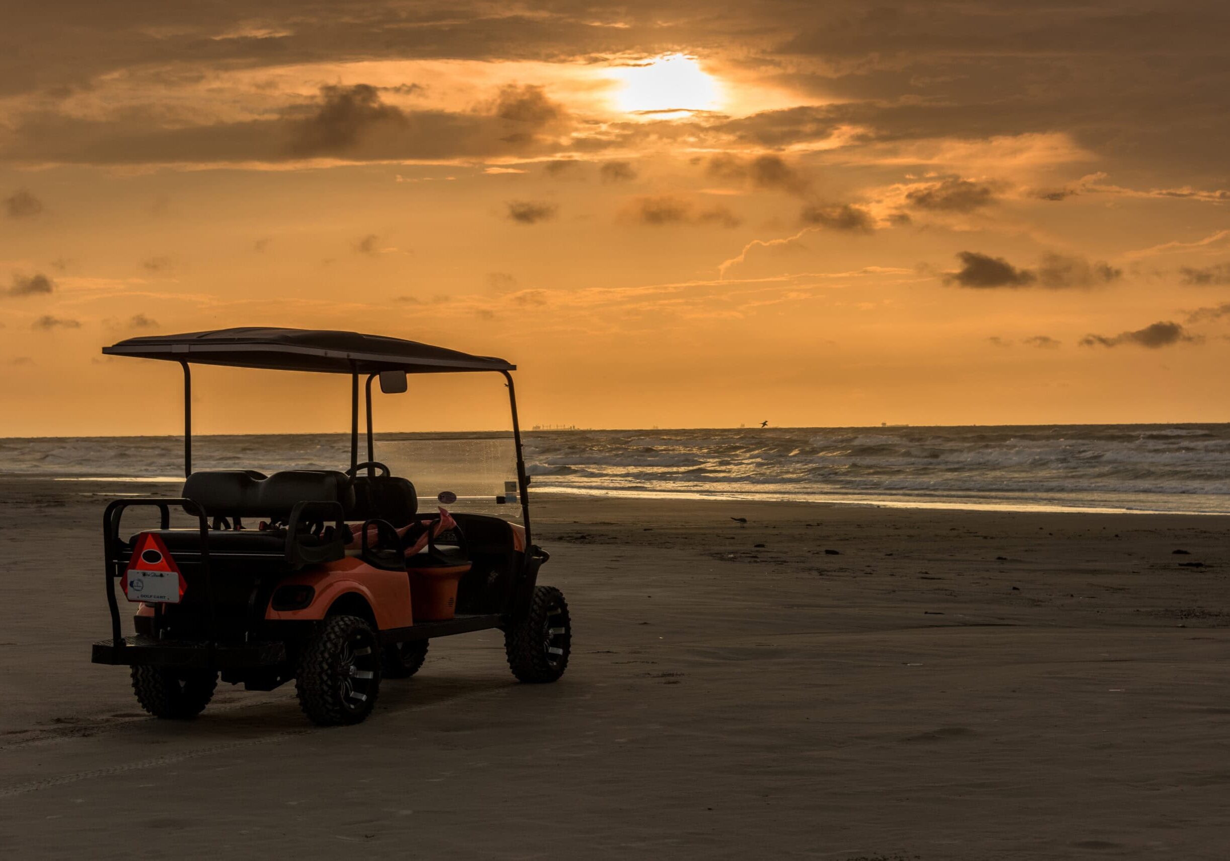 Golf cart parked on beach near sunset in Port Aransas, Texas Golf cart parked on beach near sunset in Port Aransas, Texas