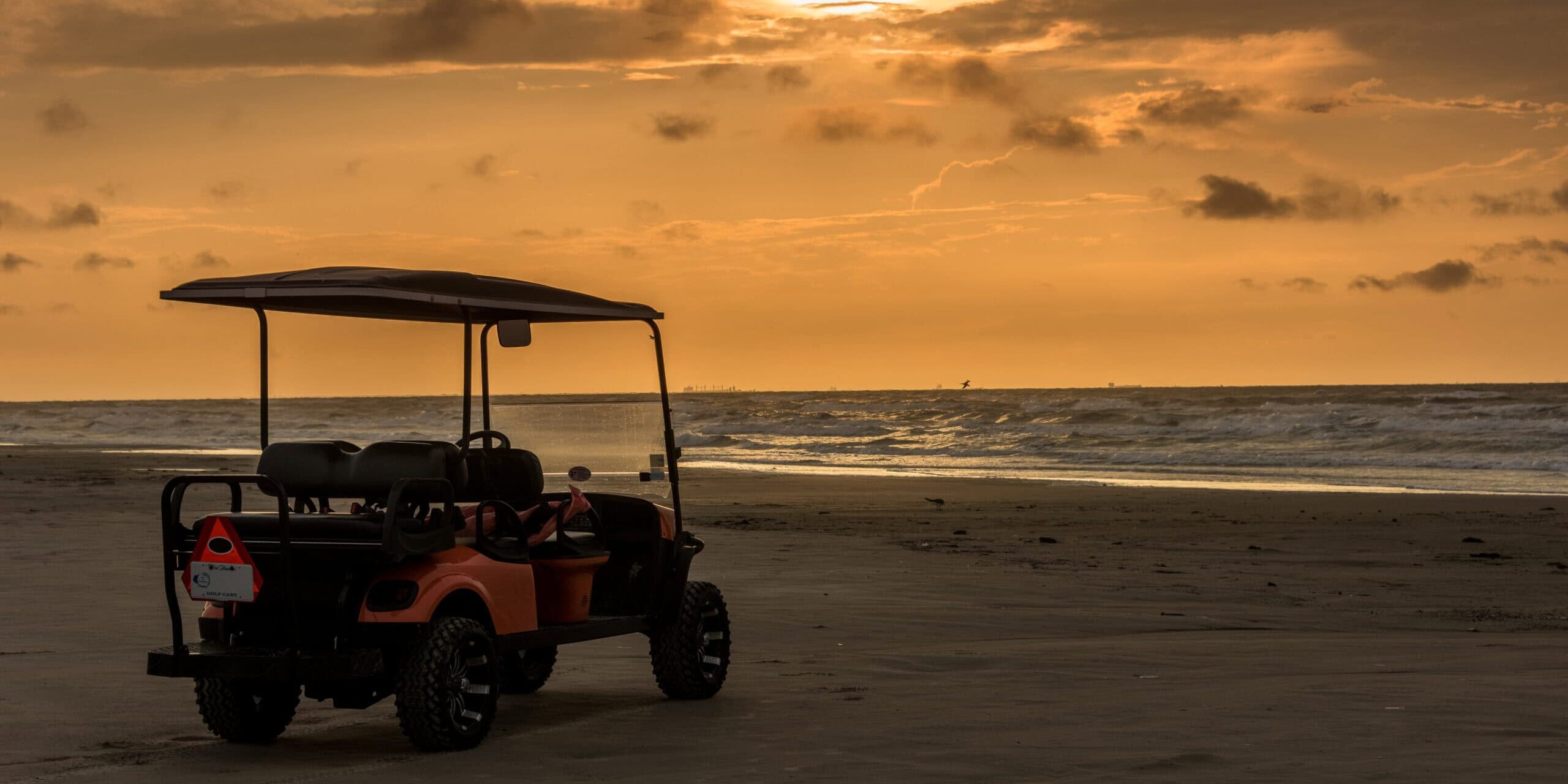 Golf cart parked on beach near sunset in Port Aransas, Texas Golf cart parked on beach near sunset in Port Aransas, Texas