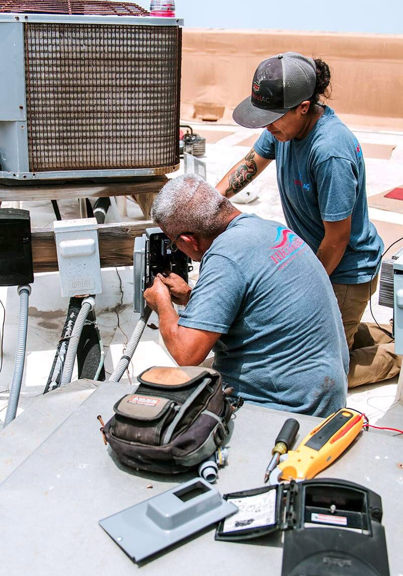 HighlandAC1-30B Highland AC technicians performing HVAC repair and air conditioning maintenance in San Antonio, working on a rooftop condenser unit.