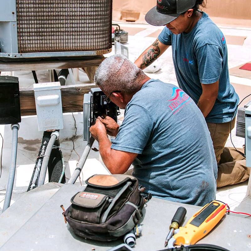 HighlandAC1-30B Highland AC technicians performing HVAC repair and air conditioning maintenance in San Antonio, working on a rooftop condenser unit.
